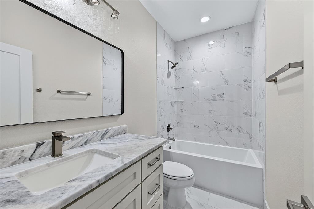 4805 Dry Creek Road Sherman, TX 75092 - Photo 25 of 29 a bathroom with a granite countertop sink a toilet and bathtub