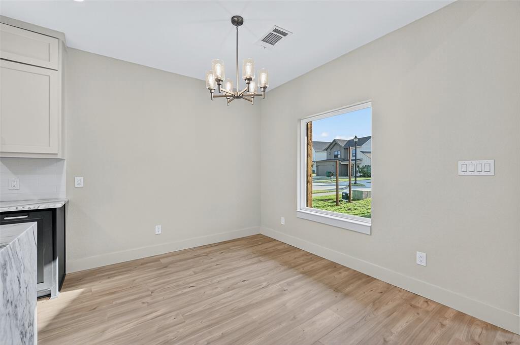 4805 Dry Creek Road Sherman, TX 75092 - Photo 7 of 29 an empty room with wooden floor chandelier and windows