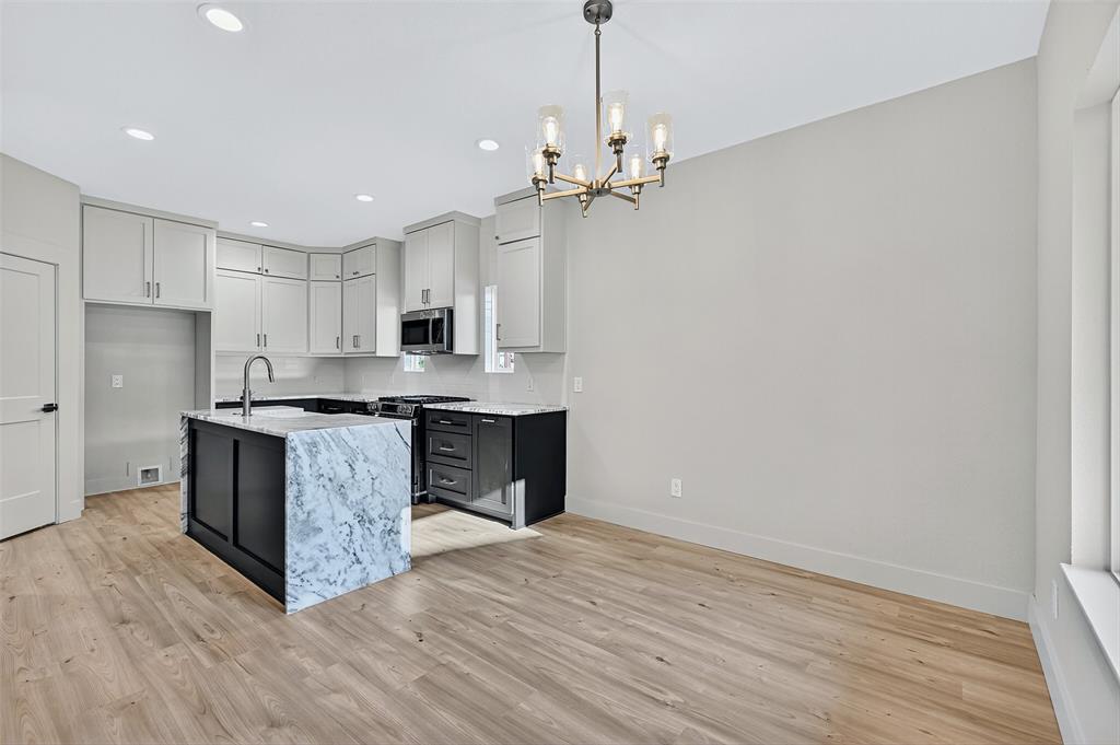 4805 Dry Creek Road Sherman, TX 75092 - Photo 8 of 29 a large kitchen with granite countertop a large counter top space a sink stainless steel appliances and cabinets