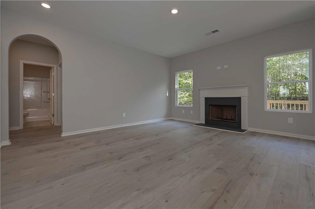 448 The Boulevard Newnan, GA 30263 - Photo 13 of 39 an empty room with a fireplace and windows