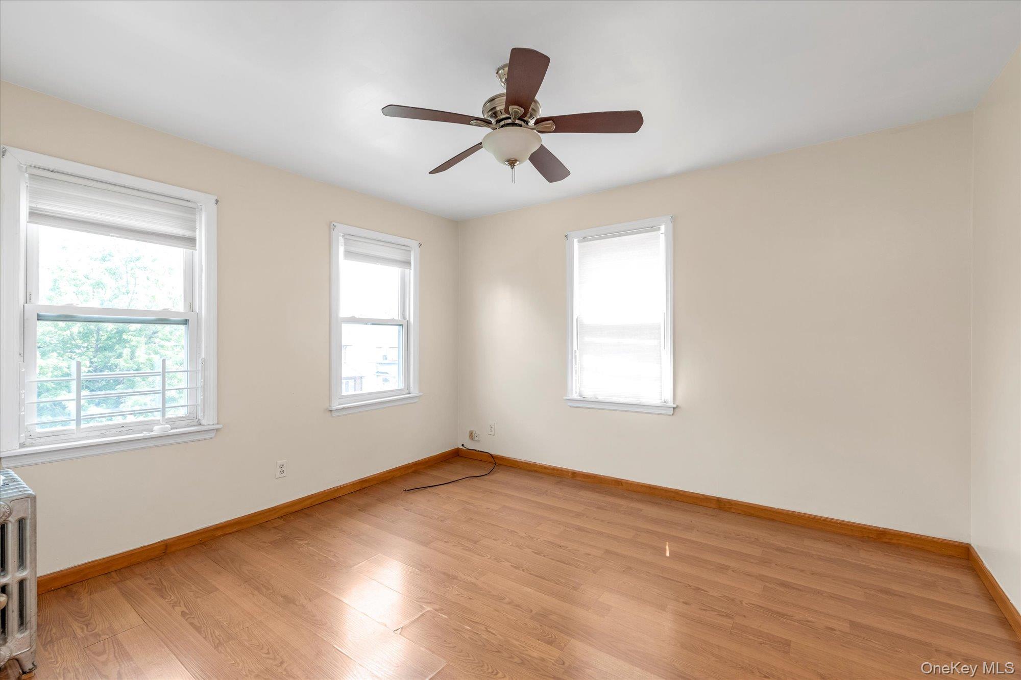 48-18 202nd Street Queens, NY 11364 - Photo 12 of 23 a view of empty room with wooden floor and fan