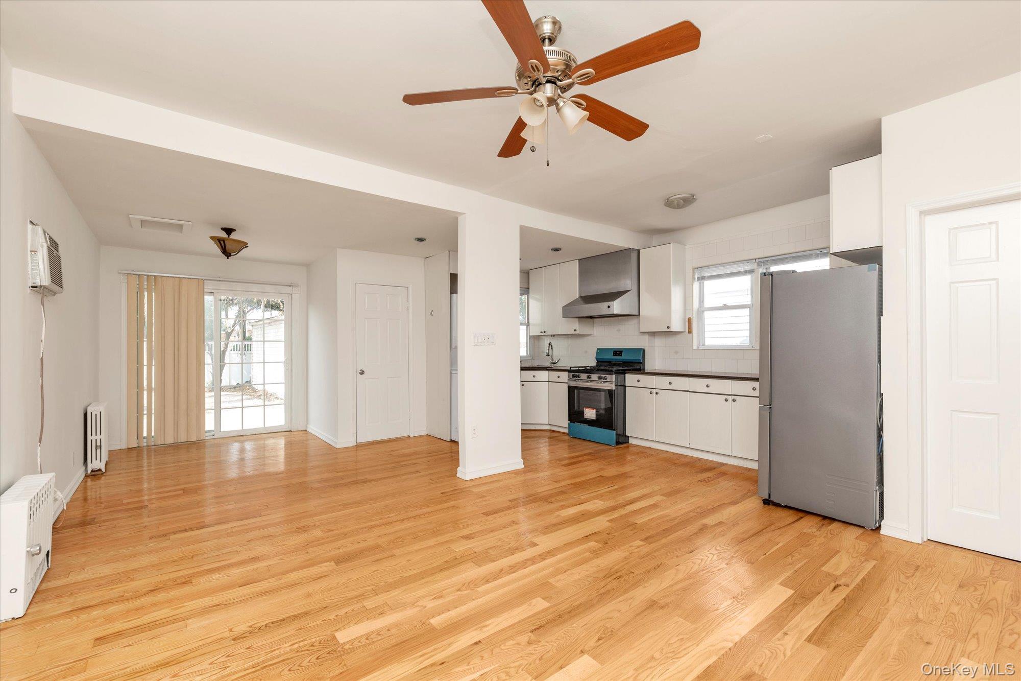 48-18 202nd Street Queens, NY 11364 - Photo 5 of 23 a kitchen with stainless steel appliances kitchen island a refrigerator sink and cabinets
