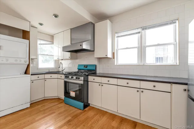 a kitchen with stainless steel appliances granite countertop a stove a sink and white cabinets