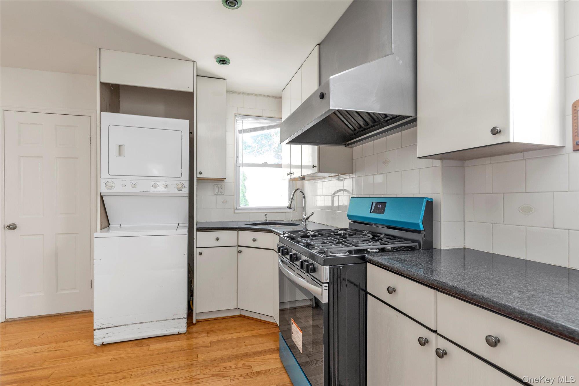 48-18 202nd Street Queens, NY 11364 - Photo 8 of 23 a kitchen with stainless steel appliances a sink a stove a refrigerator and cabinets