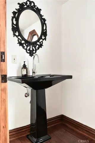 a room with a table a mirror and a wooden floor