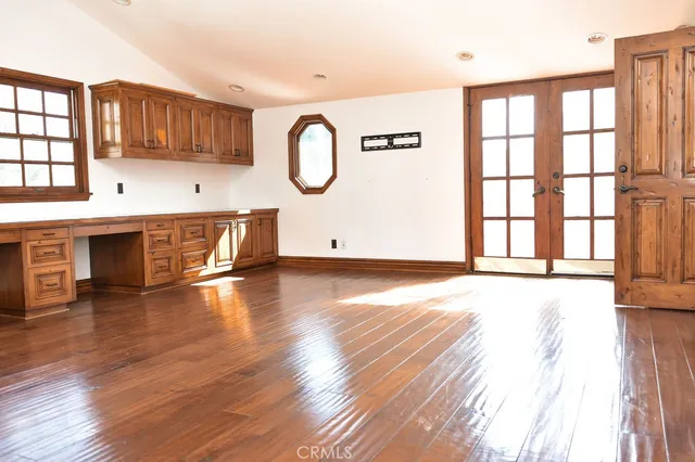 an empty room with wooden floor and window