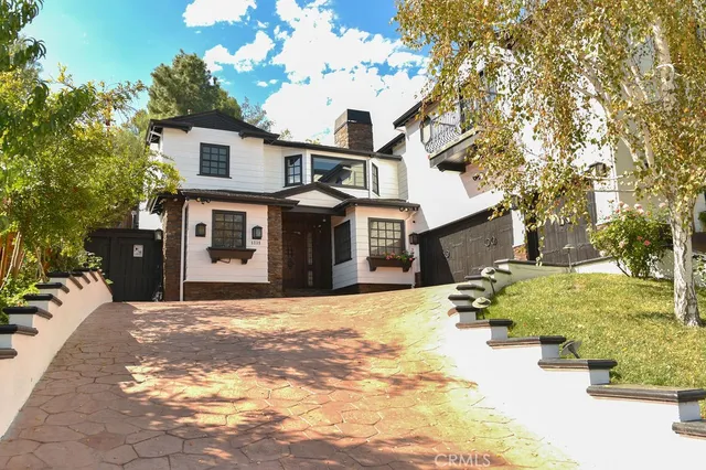 a front view of a house with a yard covered with snow