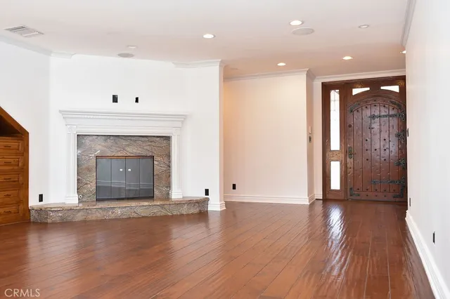 an empty room with wooden floor and fireplace