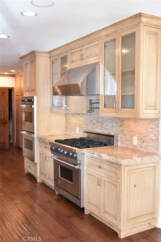 a kitchen with stainless steel appliances granite countertop a stove and a white cabinets