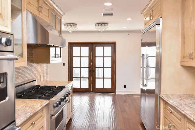 a kitchen with stainless steel appliances granite countertop a stove a sink and a refrigerator