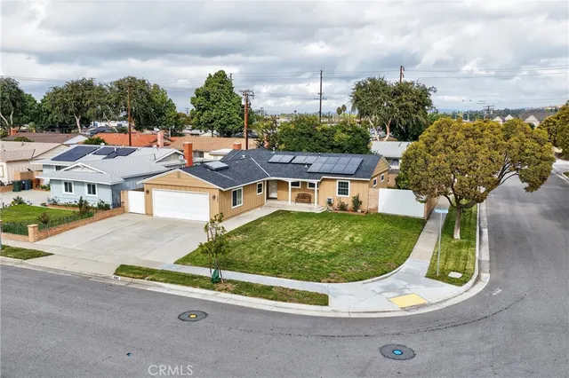 front view of house with a yard and large trees