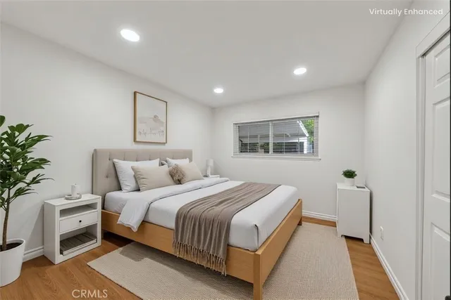 a bedroom with a large bed and a potted plant