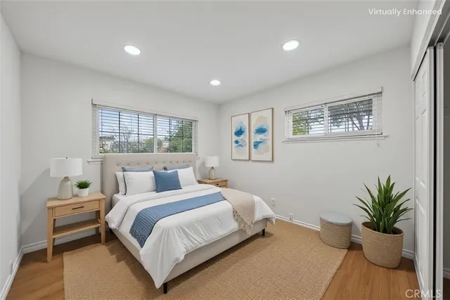 a bedroom with a large bed and a potted plant