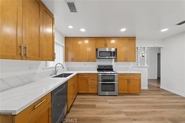 a kitchen with stainless steel appliances granite countertop a sink and a stove