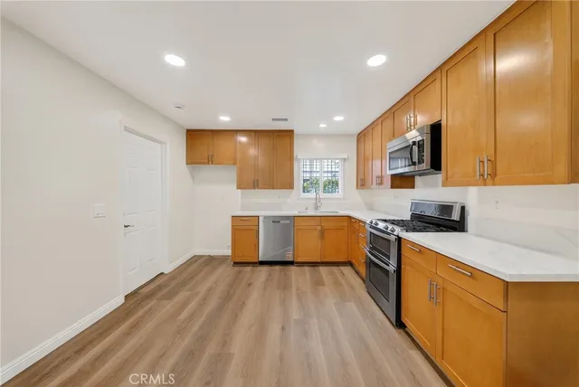 a large kitchen with stainless steel appliances granite countertop a stove a sink and a refrigerator