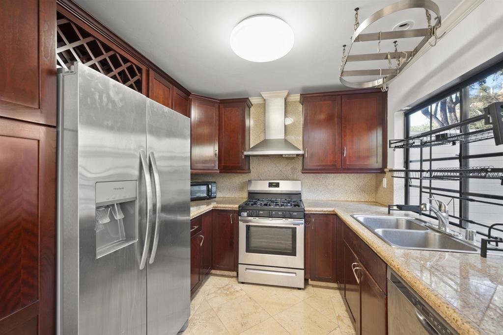 421 Windjammer Circle Chula Vista, CA 91910 - Photo 7 of 17 a kitchen with stainless steel appliances granite countertop a sink stove and refrigerator