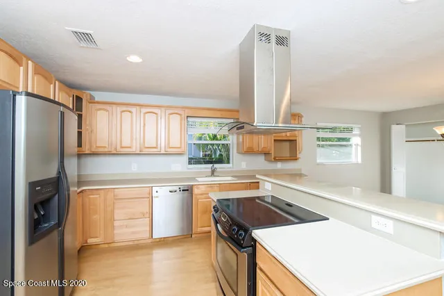 a kitchen that has a sink a stove and a refrigerator
