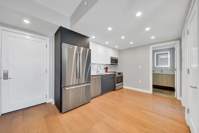 a kitchen with stainless steel appliances a refrigerator and a stove top oven