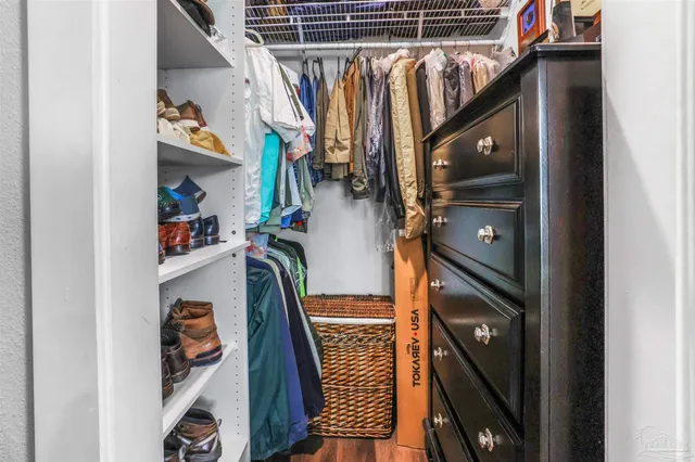 a view of walk in closet with clothes and shoes