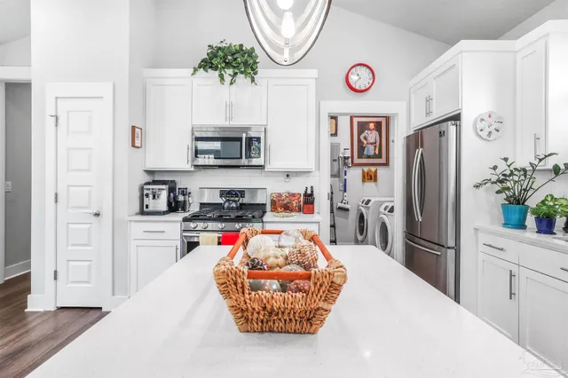 a kitchen with stainless steel appliances granite countertop a refrigerator a stove and a sink