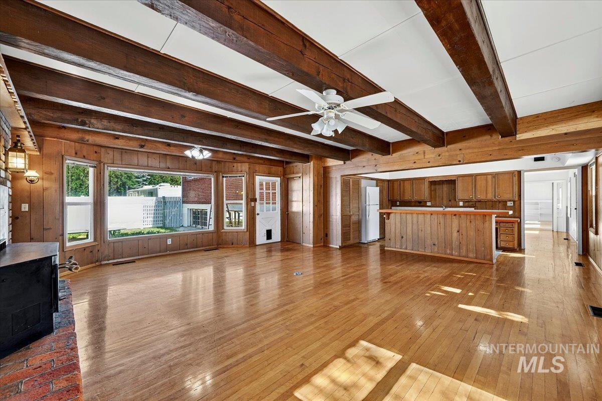 2160 South Five Mile Road Boise, ID 83709 - Photo 16 of 41 Spacious living area featuring wood-finish flooring, exposed ceiling beams, and paneled wood walls