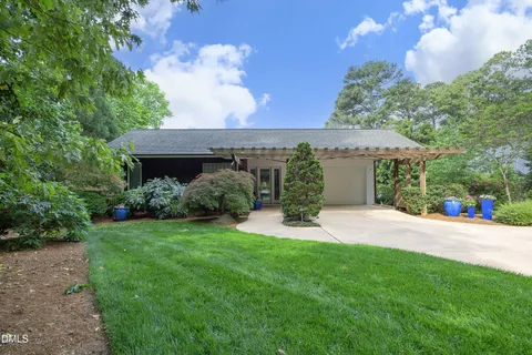 a view of a house with a yard and potted plants