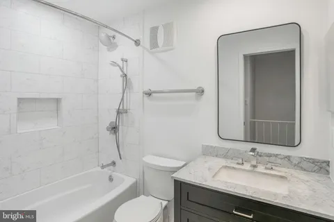 a bathroom with a granite countertop sink toilet and shower