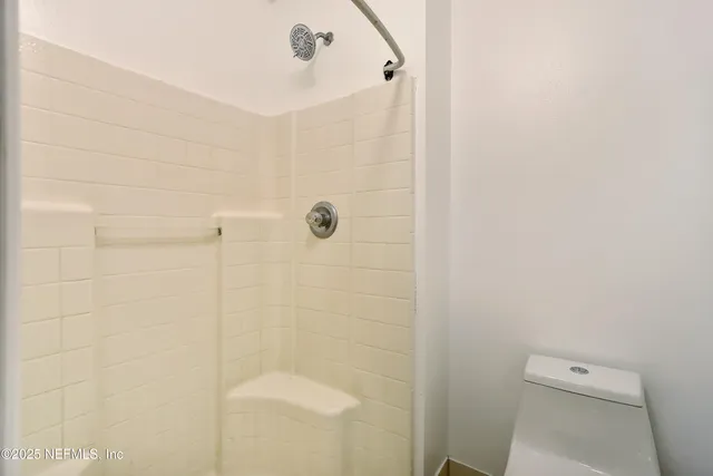 an empty room with windows and ceiling fan