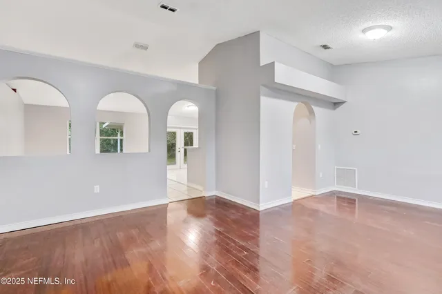 a view of empty room with wooden floor