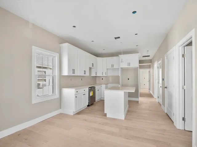 a large white kitchen with white cabinets and white appliances