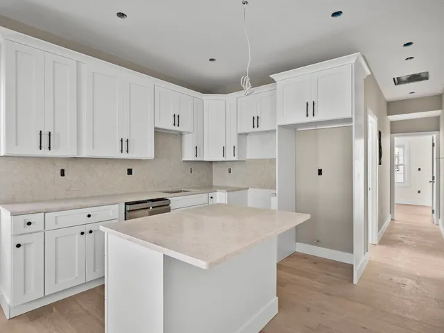 a kitchen with stainless steel appliances white cabinets and a refrigerator