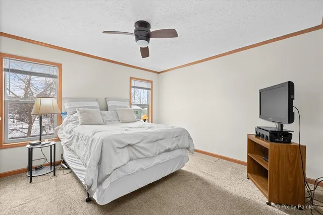 a bedroom with a bed and a flat tv screen on the dresser