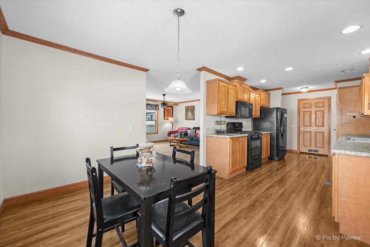 173 Northshore Road Elgin, IL 60123 - Photo 9 of 32 a kitchen with stainless steel appliances granite countertop a stove refrigerator a dining table and chairs with wooden floor