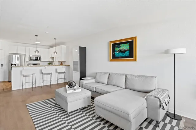 a living room with furniture and view of kitchen