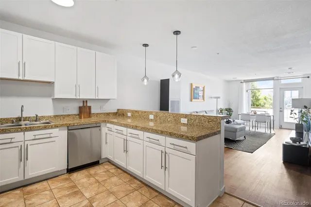 a open kitchen with stainless steel appliances granite countertop a sink and dishwasher with white cabinets