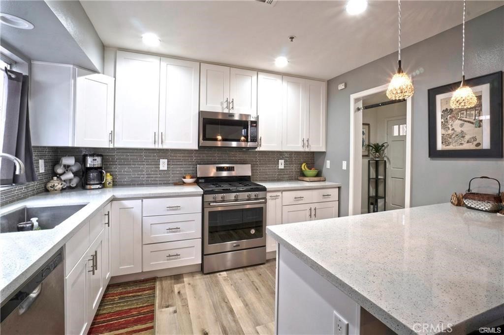 9532 Cortada Street El Monte, CA 91733 - Photo 2 of 10 a kitchen with stainless steel appliances granite countertop a sink stove refrigerator and cabinets