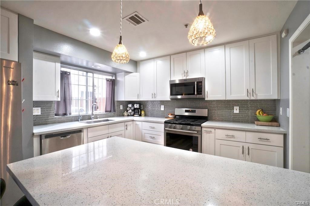 9532 Cortada Street El Monte, CA 91733 - Photo 3 of 10 a kitchen with cabinets a sink and stainless steel appliances
