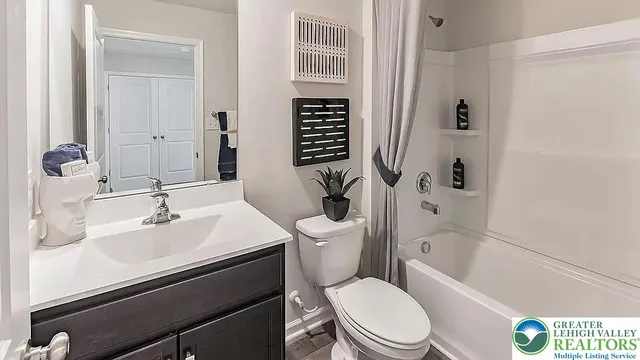a bathroom with a granite countertop sink a toilet and shower