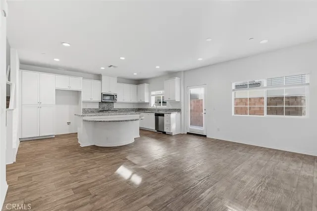 a large kitchen with stainless steel appliances kitchen island a large counter top and a stove top oven