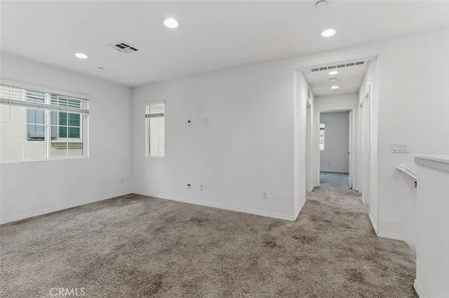 an empty room with a bathroom and a window