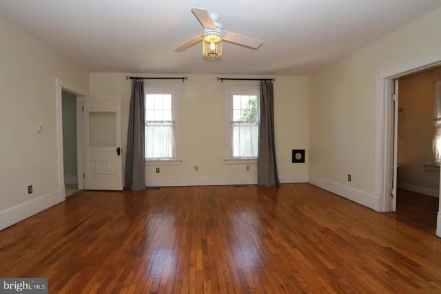 wooden floor in an empty room with a window