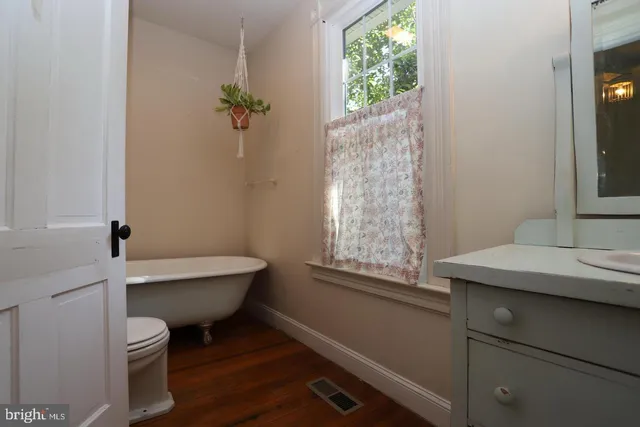 a bathroom with a toilet a sink and a window