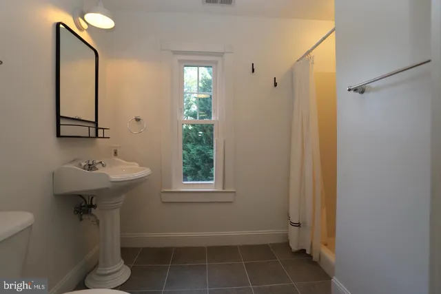 a bathroom with a sink toilet and a mirror