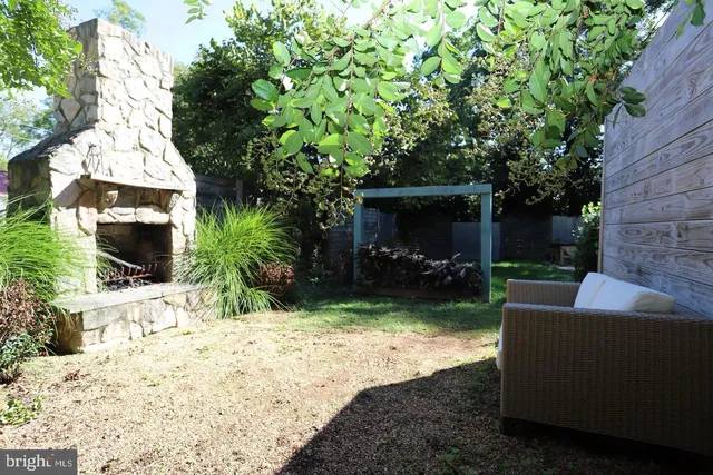a view of a backyard with couches plants and large tree