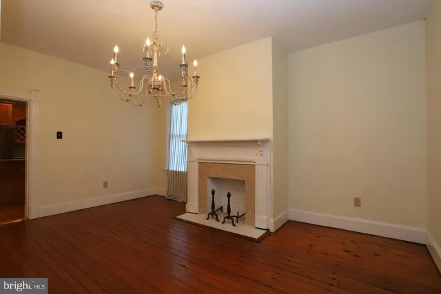 a view of a livingroom with wooden floor and a fireplace