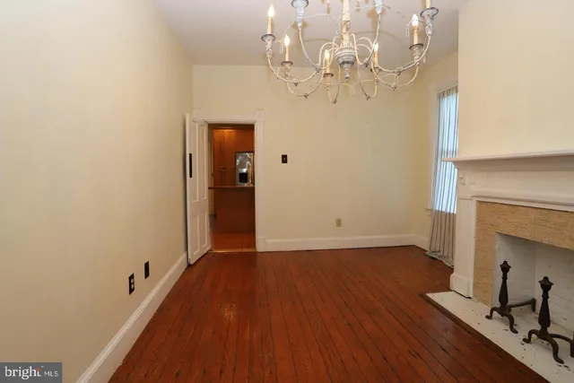 a view of a livingroom with wooden floor and a chandelier