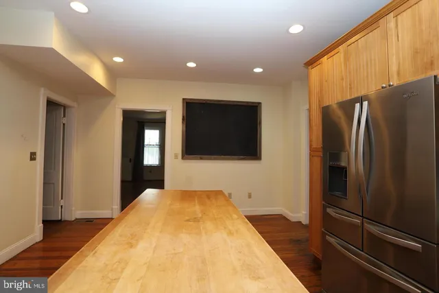 a view of a living room with a flat screen tv and refrigerator