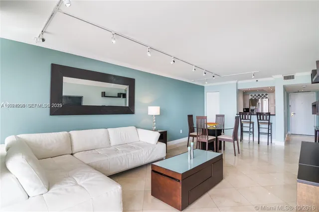 a living room with furniture and kitchen view