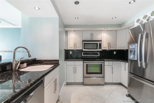 a kitchen with a sink appliances and cabinets