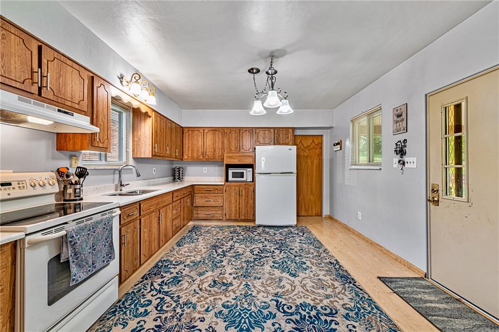 2112 Claridge Elliott Road Claridge, PA 15623 - Photo 6 of 25 a kitchen with stainless steel appliances granite countertop a refrigerator a sink dishwasher and wooden cabinets with wooden floor
